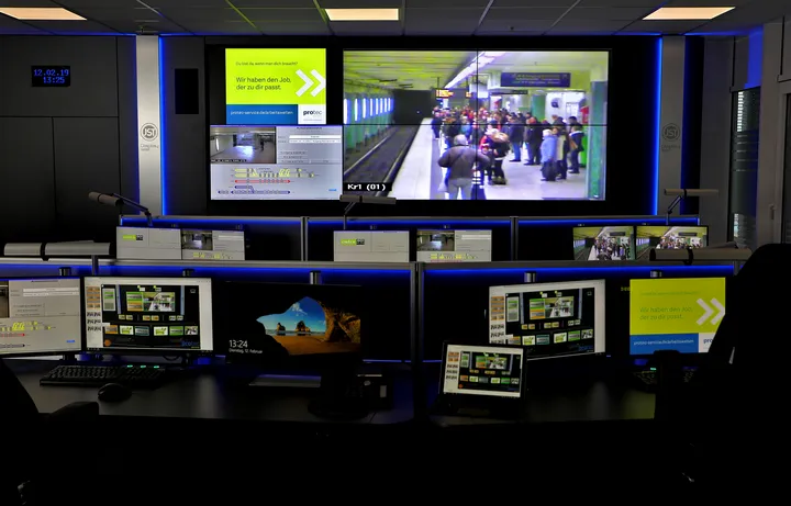 Das Bild zeigt die Leitstelle der protec mit vielen Bildschirmen, die Haltestellen und Bahnstationen in Hannover zeigen.
