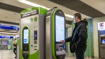 Mann bucht Fahrtkarte am Fahrkartenautomat in der Station Kröpcke.