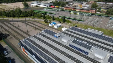 Luftaufnahme der Betriebswerkstatt Leinhausen. Auf dem Dach ist eine große Solaranlage. Im Hintergrund stehen ein paar Bahnen nebeneinander.