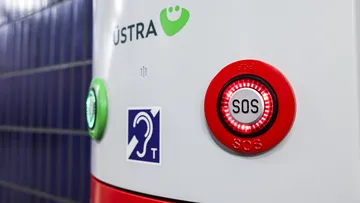 Nahaufnahme auf den rotumrandeten SOS-Knopf auf einer Notrufsäule in einer der Tunnelstationen in Hannover