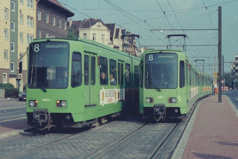 Zwei grüne Stadtbahnen fahren als Linie 8 nebeneinander.