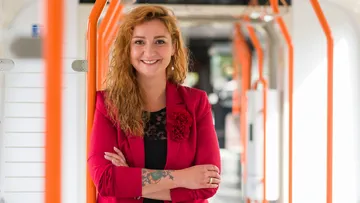 Denise Hain, Arbeitsdirektorin und Vorständin für Betrieb und Personal, steht mit verschränkten Armen in einer Stadtbahn.