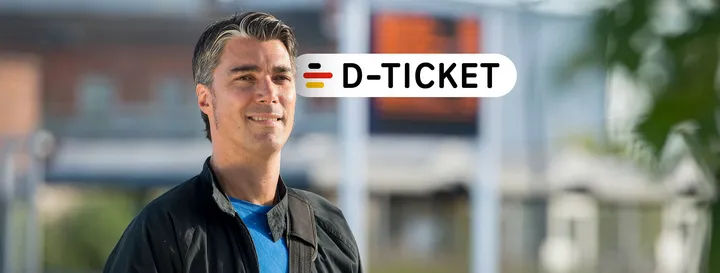 Ein Mann mittleren Alters schaut lächelnd an der Kamera vorbei, hinter seinem Kopf ist D-Ticket-Emblem zu sehen.