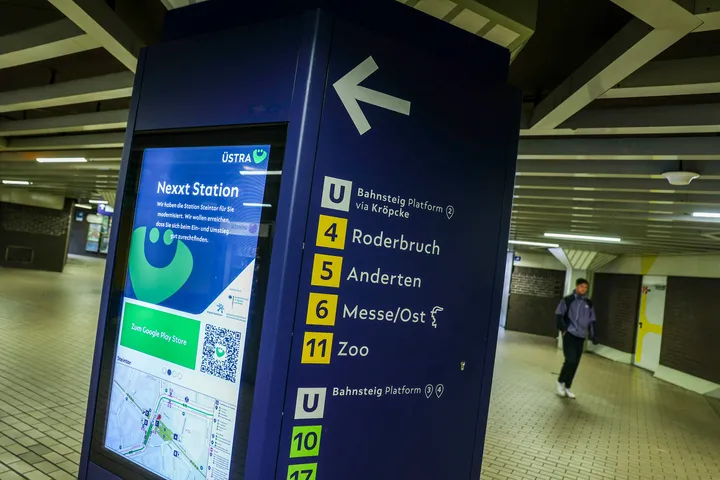 Eine Säule in der Station Steintor mit zwei Seiten. Auf der linken Seite ist ein Monitor im Hochkant-Format. Auf dem Monitor ist ÜMO zu sehen und ein Umfeldkarte vom Steintor. Auf der rechten Seite der Säule zeigt ein Pfeil nach links. Darunter stehen das U-Symbol mit dem Text "Bahnsteig Platform 2 via Kröocke" und die Linien 4, 5, 6 und 11 mit den jeweiligen Endpunkten Roderbruch, Anderten, Messe/Ost und Zoo. Darunter ist noch ein U-Symbol mit dem Text "Bahnsteig Platform 3 und 4" und die Linien 10 und 17.