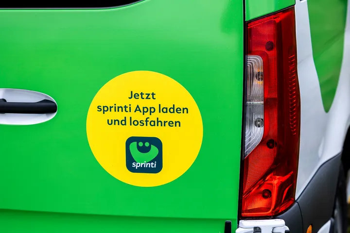 Rückseite sprinti Bus mit Beklebung "Jetzt sprinti App laden und losfahren"