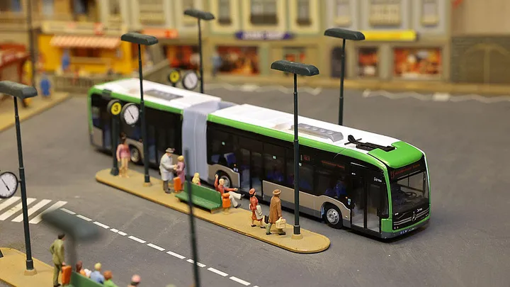 Modell eines eCitaro Gelenkbusses an einer Modell-Bushaltestelle