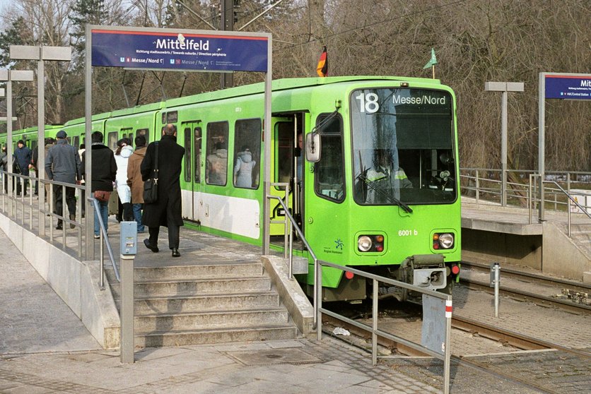 Eine grüne Stadtbahn hält als Linie 18 an der Haltestelle Mittelfeld.