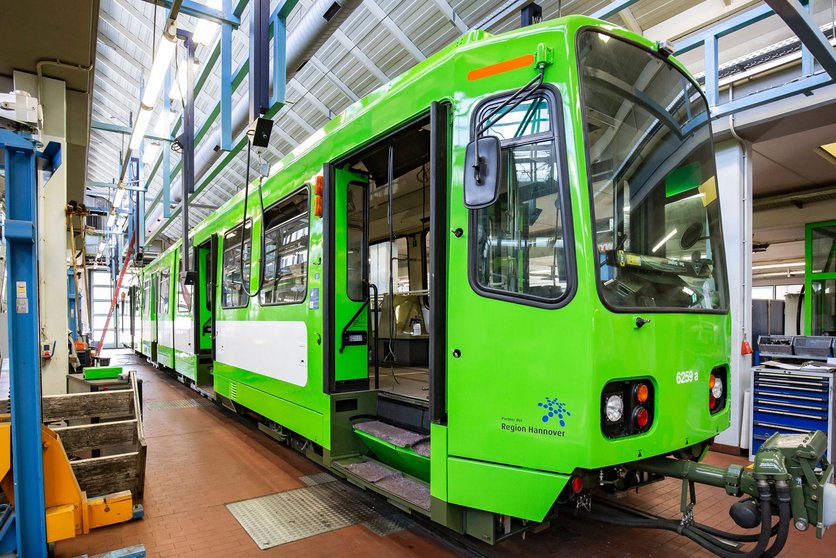 Eine grüne Stadtbahn steht mit geöffneten Türen in der Werkstatt.