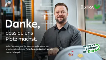 Ein Vater sitzt mit Kinderwagen im Mehrzweckbereich in der Stadtbahn.