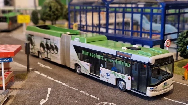 Modell eines Solaris Hybrid Busses mit der Aufschrift "Klimaschutz ist unser Antrieb"