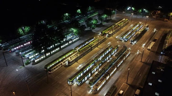 Luftaufnahme des Betriebshofes Glocksee bei Nacht. Viele beleuchtete Bahnen stehen nebeneinander und hintereinander.