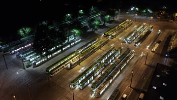 Luftaufnahme des Betriebshofes Glocksee bei Nacht. Viele beleuchtete Bahnen stehen nebeneinander und hintereinander.