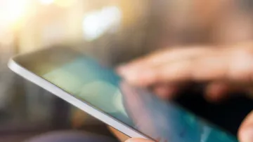 Nahaufnahme auf ein Handy, das jemand in der Hand hält.