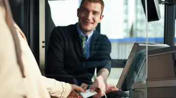 Busfahrer verkauft Fahrgast eine Fahrkarte im Bus