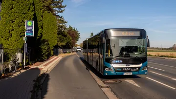 Ein M A N Hybridbus auf der Linie 500 in Richtung Gehrden fährt bei Sonnenschein an der Haltestelle Ronnenberg Ihmer Tor.