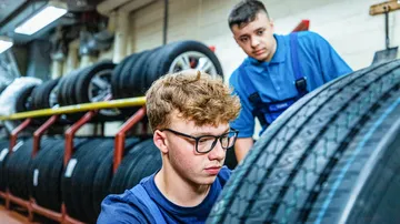 Zwei Azubis betrachten einen Reifen im Lager
