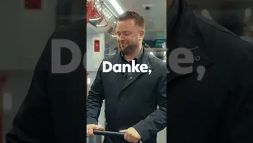 Ein Hochkant-Video, in dem ein Mann mit Kinderwagen in eine Stadtbahn steigt. Im Mehrzweckabteil sitzt ein anderer Mann am Handy, der aufsteht und Platz macht für den Mann mit Kinderwagen. Es wird eingeblendet "Danke, dass du uns Platz machst"