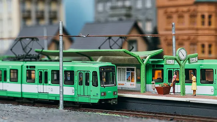 Modell einer Stadtbahn des Typ TW 6000 in grün an einer Modell-Haltestelle