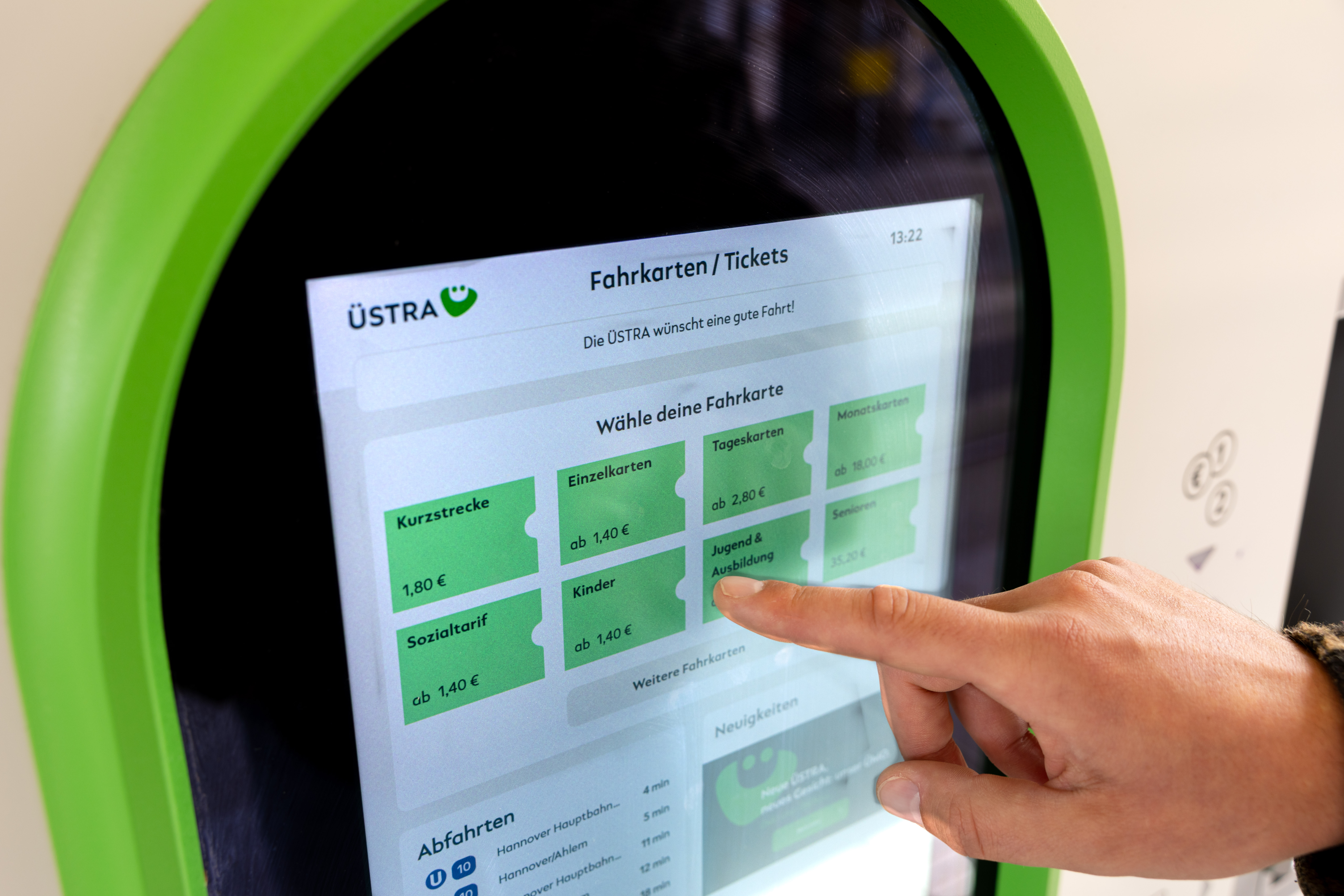 Ein Finger zeigt auf diverse Tickets im Display eines Fahrkarten-Terminals